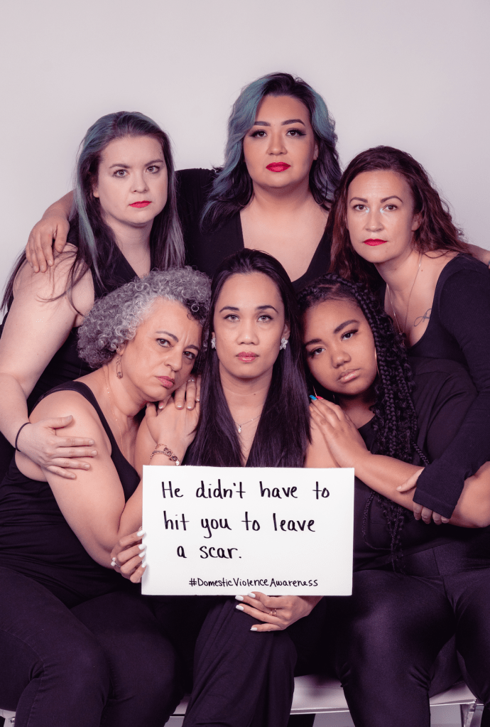 People of different backgrounds and races holding a sign that says "He didn't have to hit you to leave a scar."